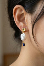 Ohrringe Marleen – Model trägt vergoldete Ohrringe mit Barockperle und blauem Lapislazuli